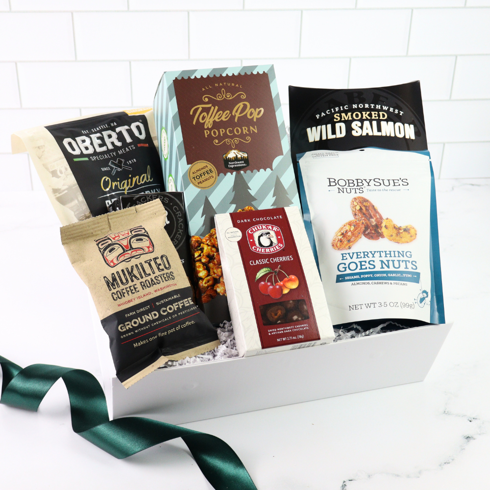 Assorted snack items including Oberto, Toffee Popcorn, and Bobby Sue's Nuts in a box with a green ribbon.